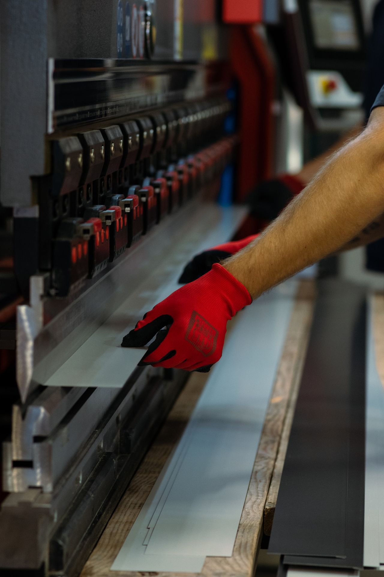 a man wearing red gloves is working on a machine